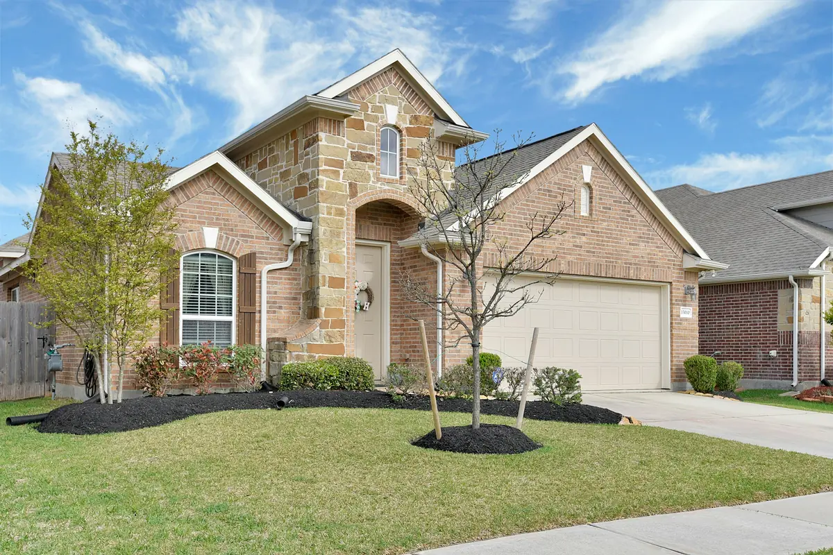 White long-panel two-car garage door on a brick home